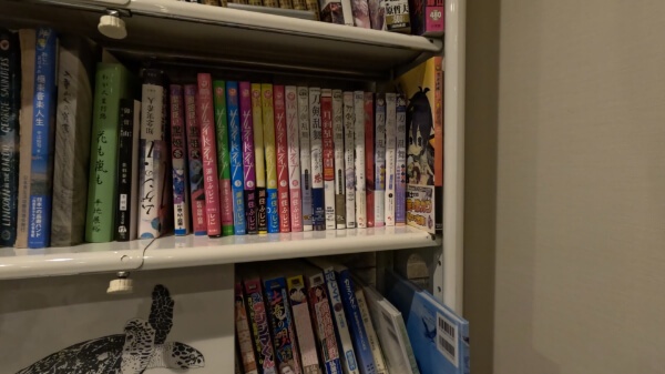 ゲストハウスの漫画コーナー（刀剣乱舞アンソロジーが多数）